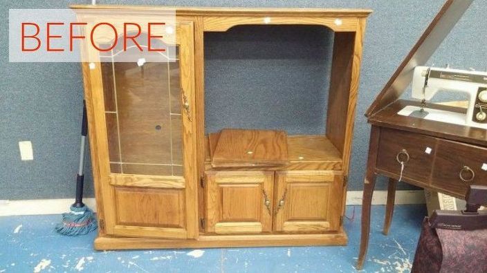 a wooden cabinet sitting next to a mirror on top of a blue carpeted floor