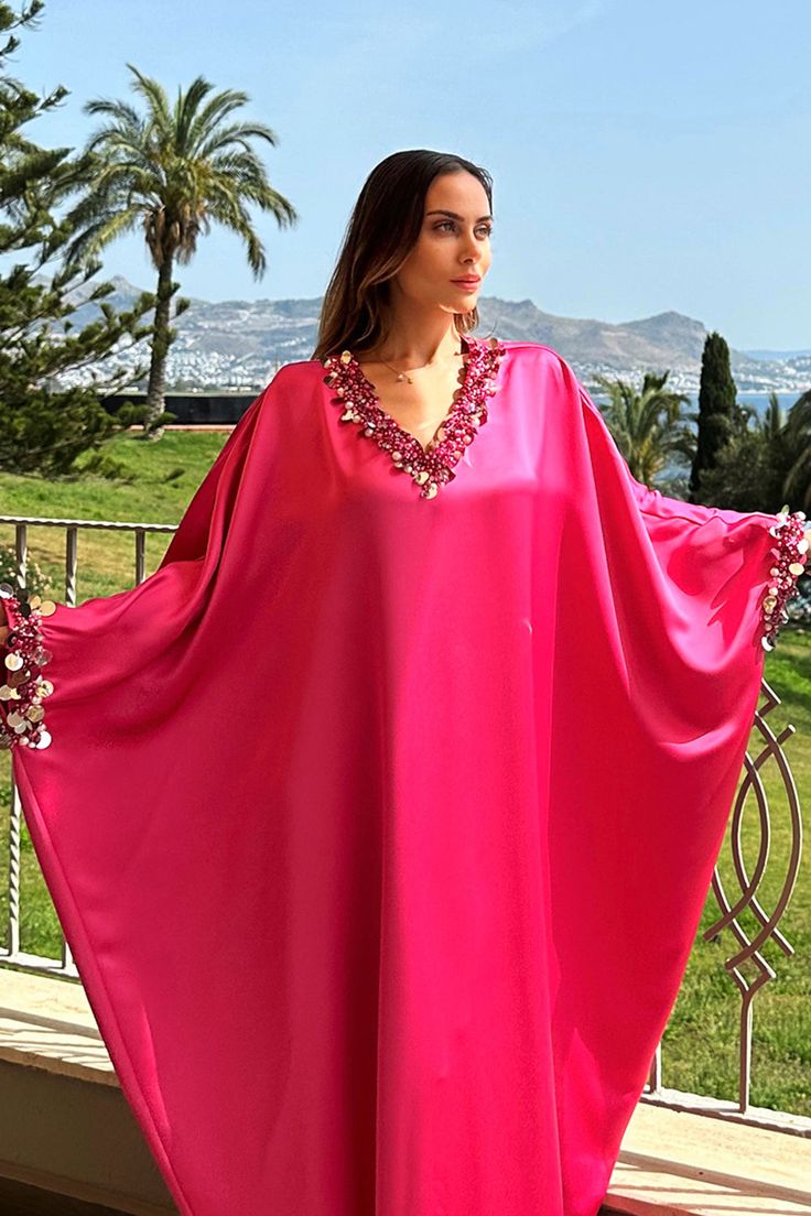 The overall effect is a dress fit for royalty, combining traditional caftan elements with modern sophistication. As the wearer moves, the premium handmade pearl beading embellishment adds elegant, stylish, and fun vibes to your look. This caftan dress is a true work of art, embodying the grandeur and luxury associated with royal fashion and a perfect choice on a fun summer day. Whether you are going to a resort, vacation, or any special celebration you are sure to stand out in this statement pie Festive Embellished V-neck Kaftan, Summer Festive Hand Embellished Kaftan, Pink V-neck Kaftan For Evening, Pink Sequined Kaftan For Party, Traditional Pink Kaftan For Party, Pink Party Kaftan With Sequins, Silk Sequined Kaftan For Parties, Silk Sequined Party Kaftan, Silk Kaftan With Sequins For Party