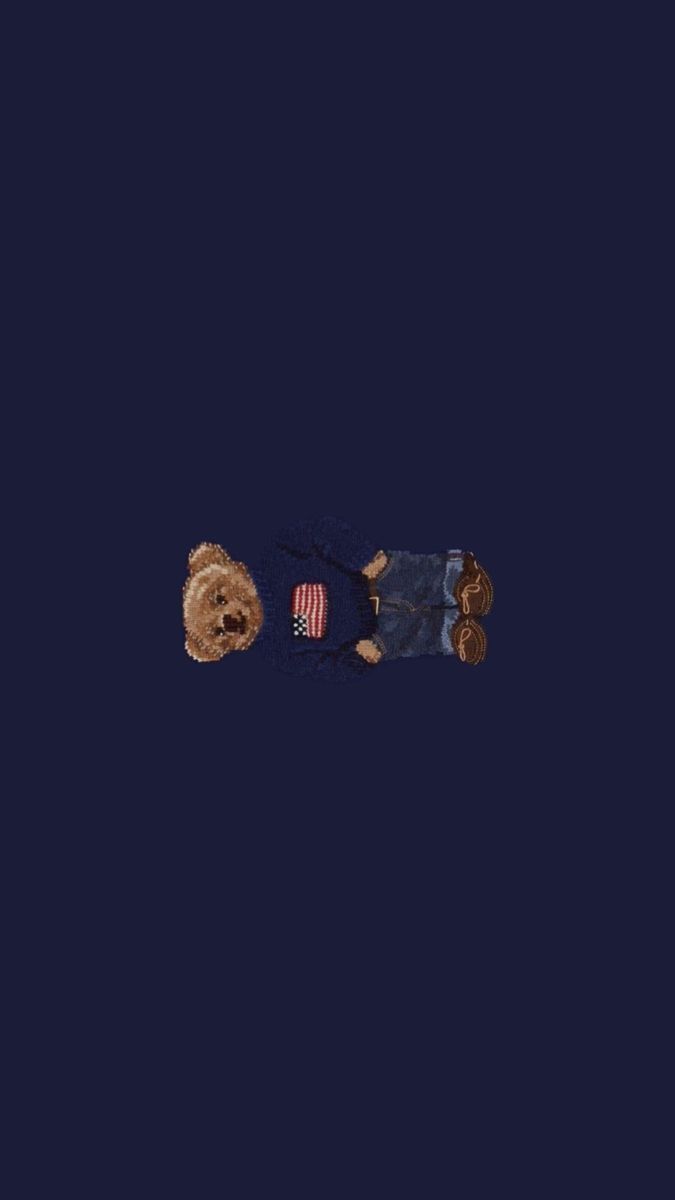 two teddy bears laying on the ground with one holding an american flag in its lap