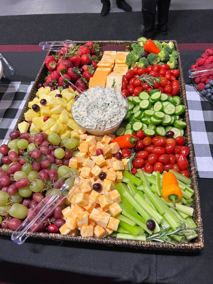 a platter filled with lots of different types of fruits and vegetables on a table