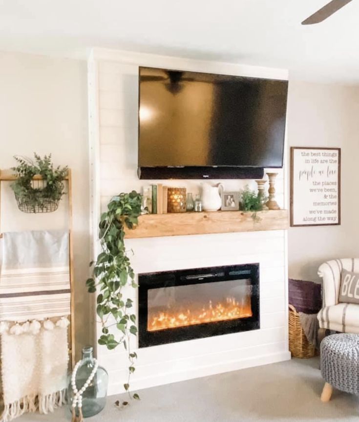 a living room with a fireplace and television mounted on the wall