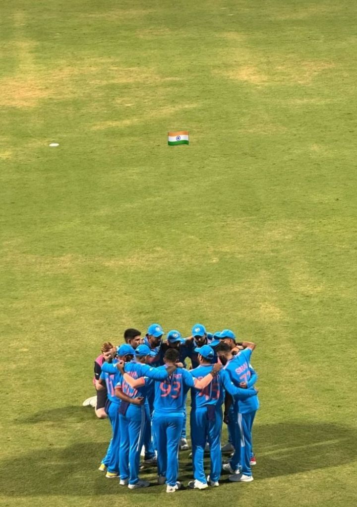 a group of young men standing on top of a lush green field next to each other