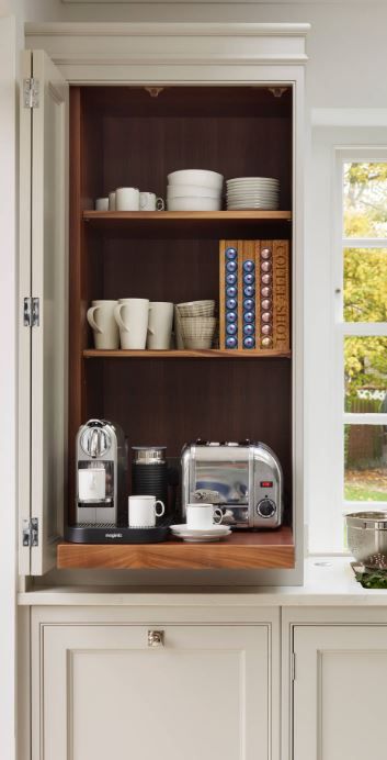 a kitchen with white cupboards and shelves filled with dishes on top of each other