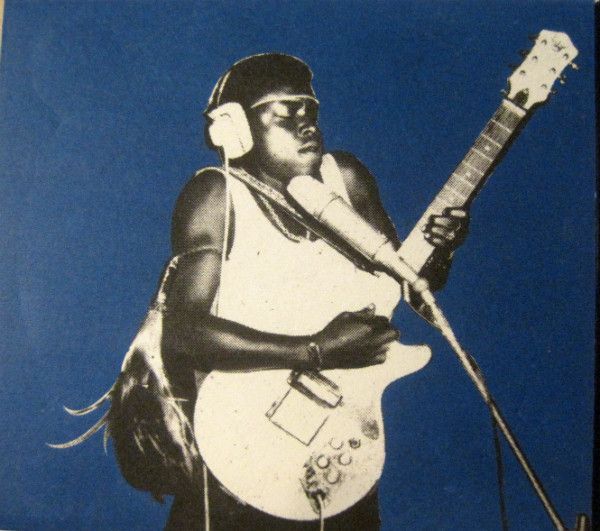 a man with headphones on holding a guitar and microphone in front of a blue background