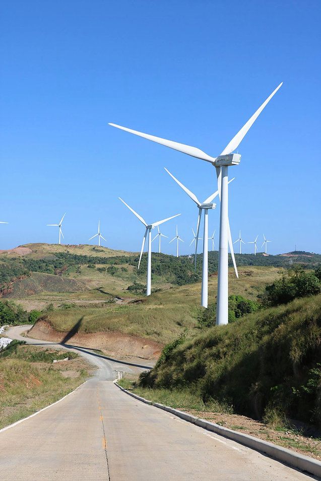 several wind turbines on the side of a road