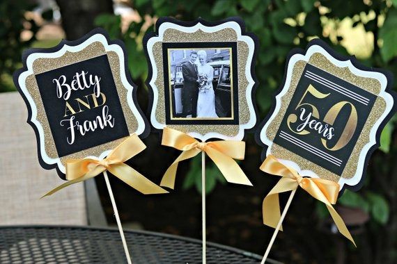 a table topped with cake covered in frosting next to pictures on top of sticks