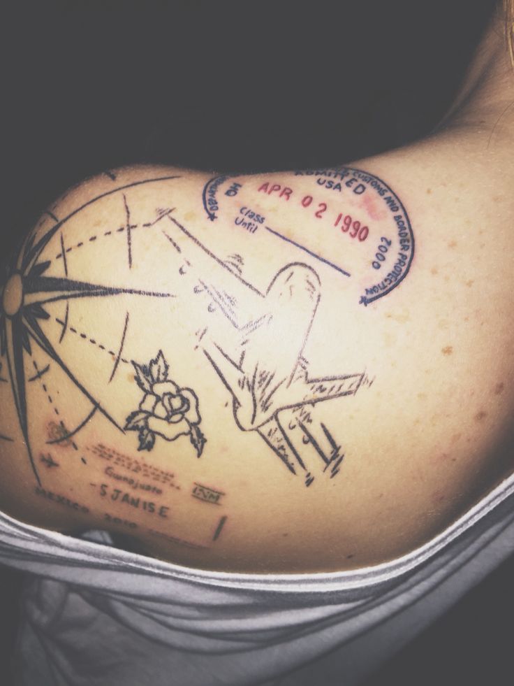 the back of a woman's shoulder with an airplane and stars tattoo on it