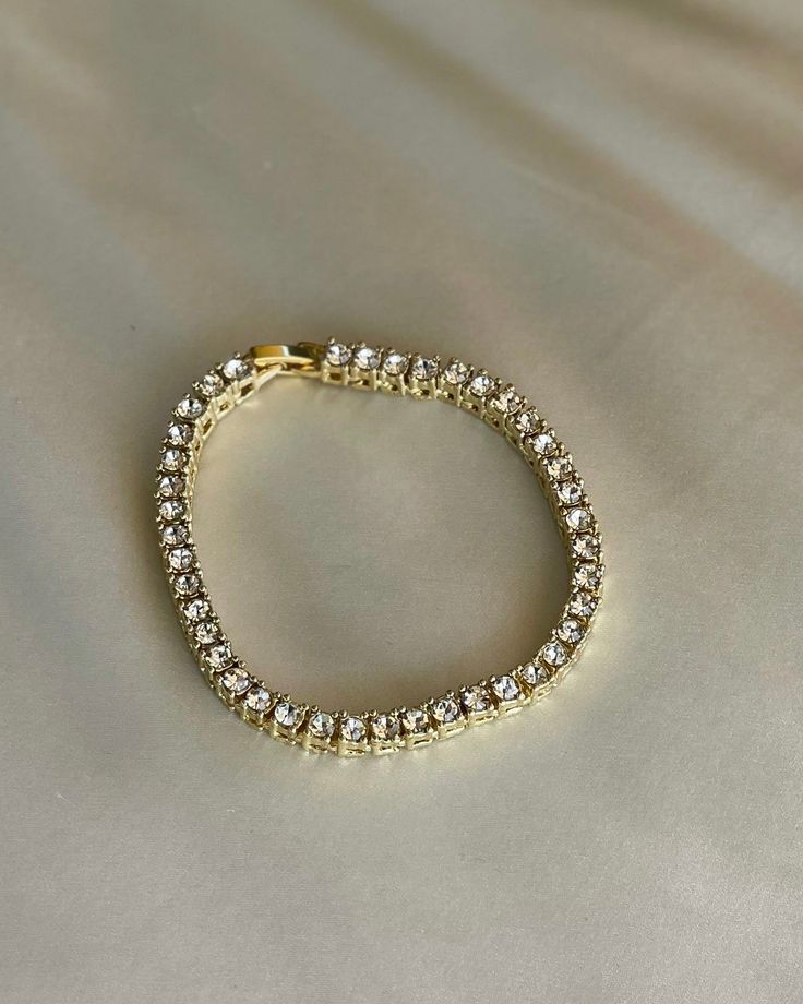 The Lya Bracelet is a touch of sophistication and glamour. Perfect on its own or layered with your favorite bracelets. It is made of gold plated brass and cubic zirconia. It is 7 inches in length. Glamorous Diamond Bangle Bracelet, Glamorous Diamond Bracelet For Gift, Gold Cubic Zirconia Jewelry With Bling, Glamorous Yellow Gold Jewelry With Sparkling Stones, Glamorous Cubic Zirconia Diamond Bracelet With Accents, Gold Plated Bracelets With Sparkling Stones, Party Cubic Zirconia Hand Set Tennis Bracelet, Party Hand-set Cubic Zirconia Tennis Bracelet, Luxury Yellow Gold Tennis Bracelet With Sparkling Stones