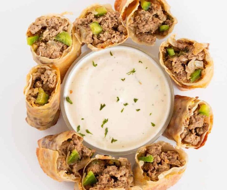 an overhead view of some appetizers on a plate with a dip in the middle