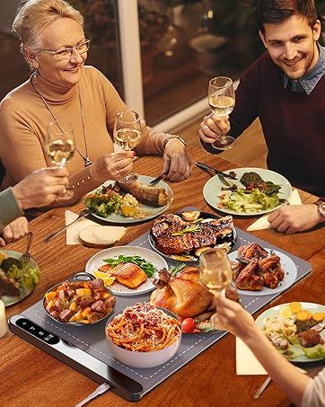 a group of people sitting around a table with food and wine glasses in their hands