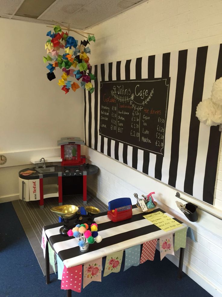 there is a table with many items on it in front of a chalkboard wall