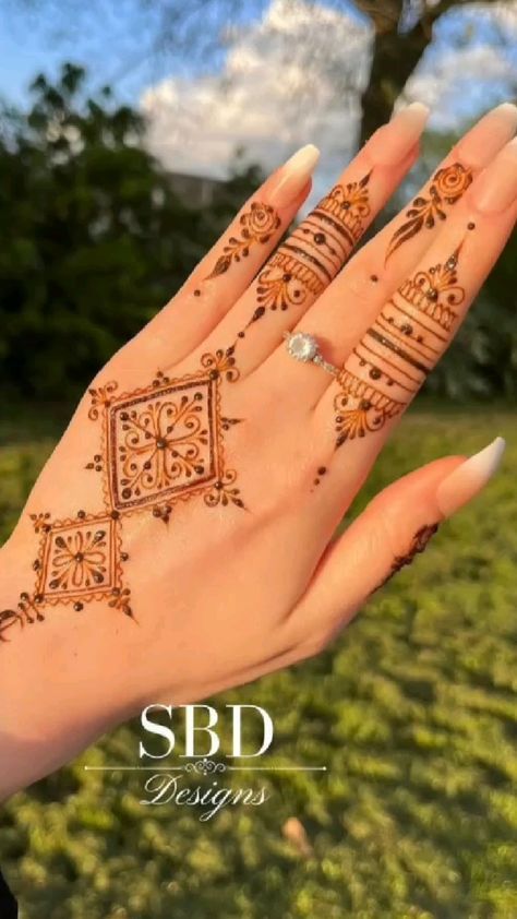 a woman's hand with henna tattoos on it