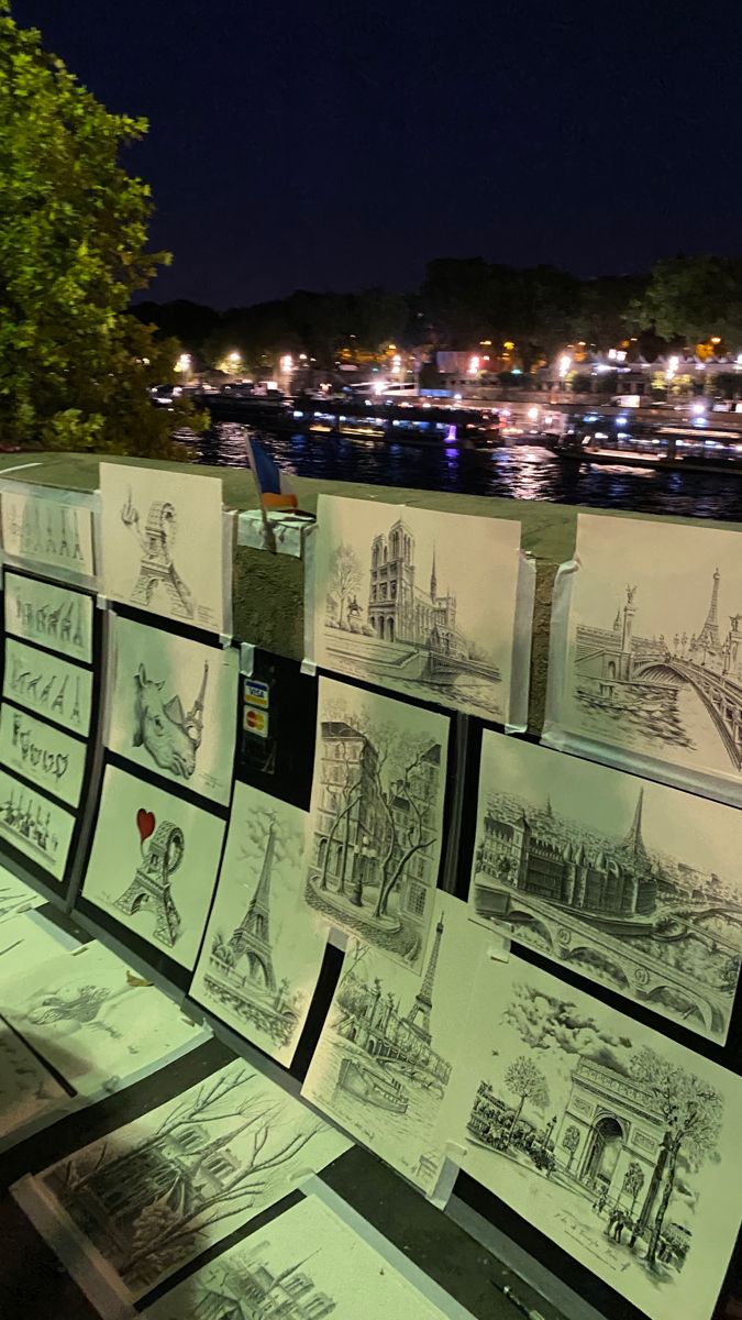 many drawings are on display at night by the water