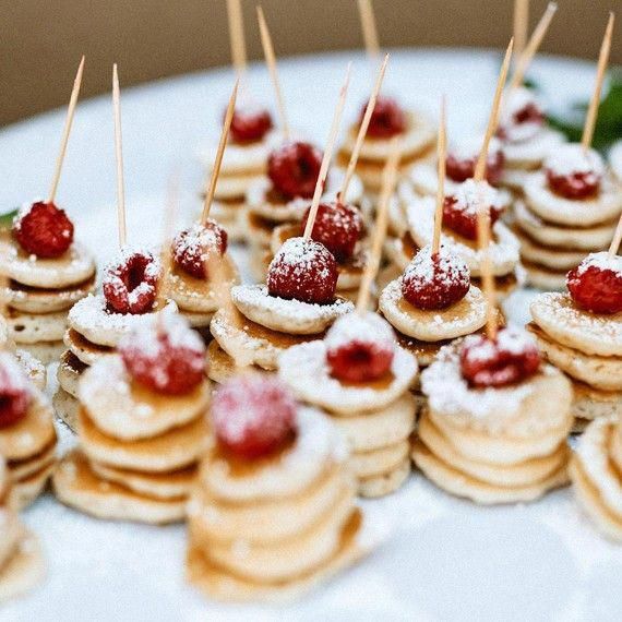 small desserts are arranged on a plate with toothpicks