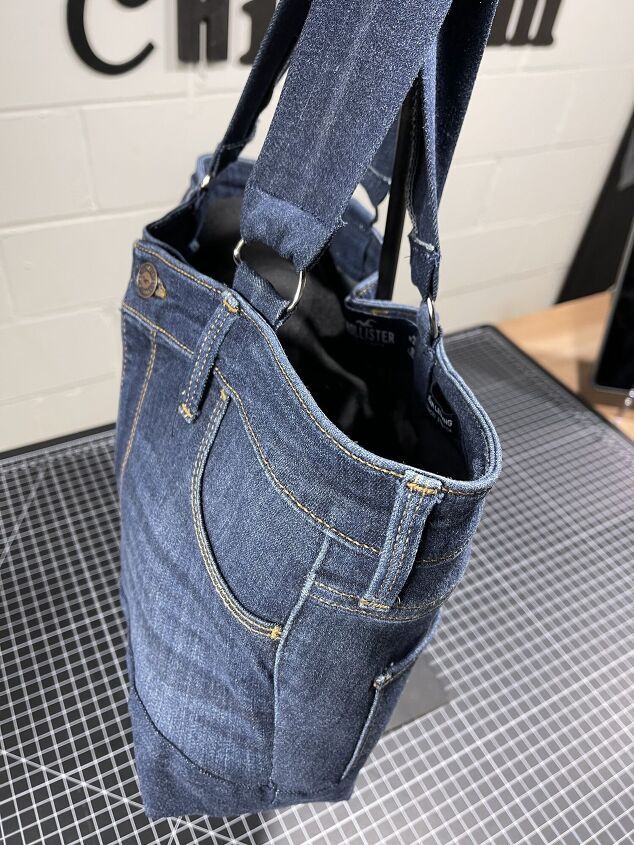 a denim bag hanging from the side of a wall