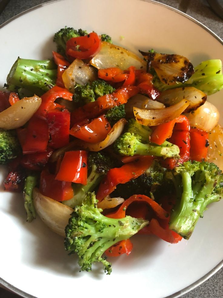 a white plate topped with broccoli and red peppers