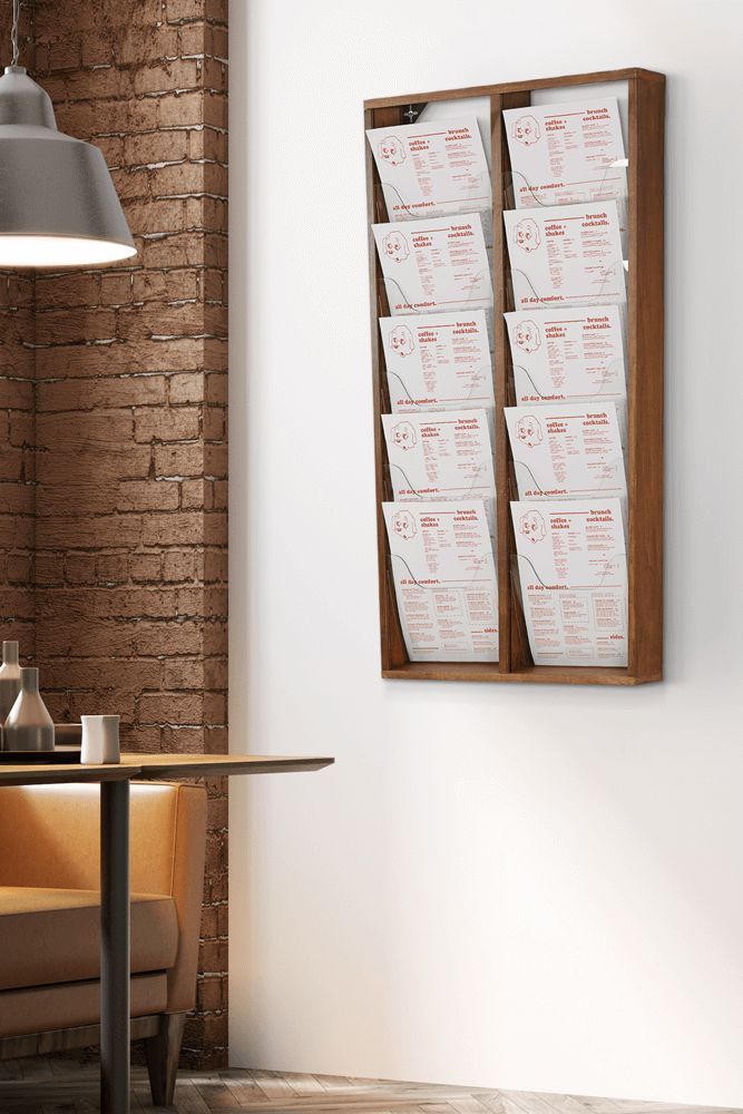 a wall mounted wooden menu board on a brick wall next to a table and chair