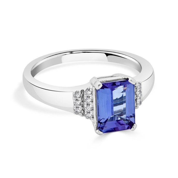 Set with a spectacular emerald cut Tanzanite, this enchanting ring complements your style perfectly. Crafted of lustrous 14K white gold, this arresting ring is bordered by shimmering round cut Diamonds that give it a mesmerizing finish. Product Information SKU ADG50841/7 Metal Type 14K Metal Color White Gold Ring Style Solitaire Primary Stone Gemstone Name Tanzanite Gemstone Species Zoisite No. Of Gemstones 1 Gemstone Shape Emerald Cut Gemstone Weight 1.70 Gemstone Size 8x6 Origin Tanzania Secon Ring Emerald, Tanzanite Ring, Tanzanite Gemstone, Ring Style, White Gold Ring, Round Cut Diamond, Metal Color, Diamond Gemstone, White Gold Rings