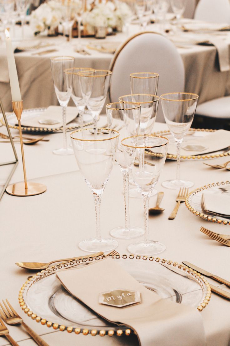 the table is set with gold and white place settings