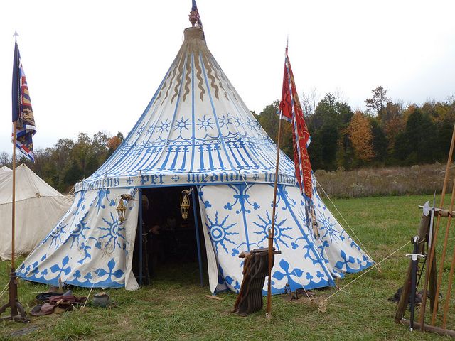 a tent that has been decorated with blue and white designs on the front, sitting in a field