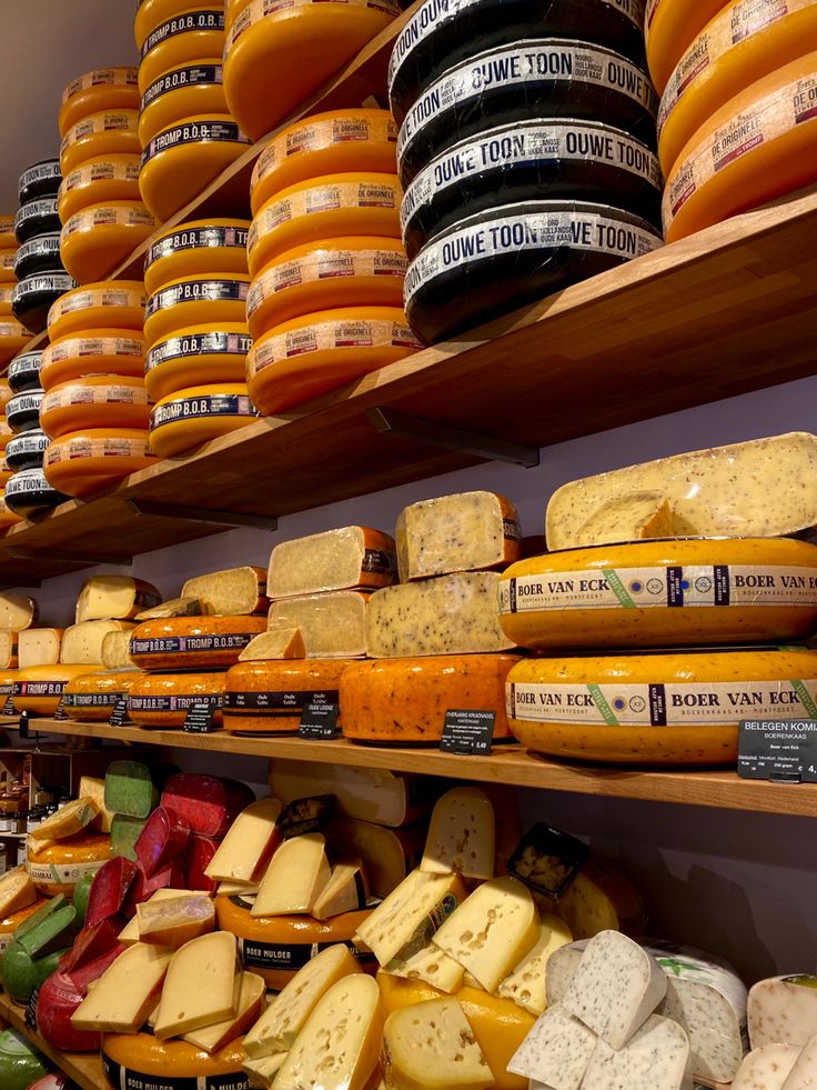 many different types of cheese on shelves in a store