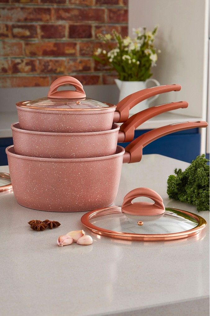 pink pots and pans sitting on top of a counter