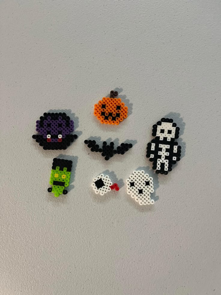 some pixelated objects are laying on the floor together and one has a pumpkin, ghost, spider, and other items