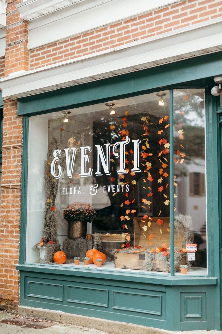 the front window of a store with pumpkins and other decorations