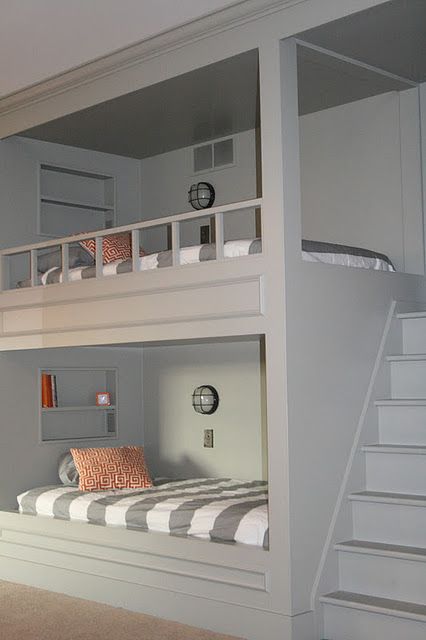 the bunk bed is built into the side of the wall and has stairs leading up to it