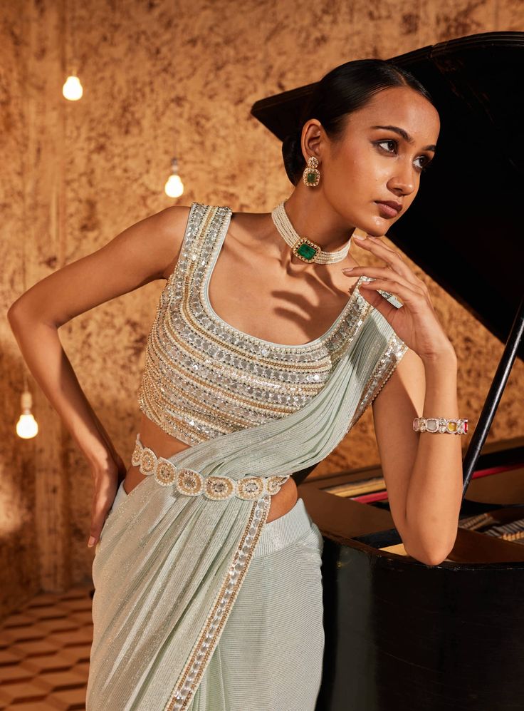 Elevate your style with this aqua drape sari, showcasing intricate embroidery on the sari border. The fully embroidered blouse steals the spotlight, and the outfit is both padded and secured with a hook-eye closure on the back, ensuring a perfect fit. Embrace the grace and charm of this ensemble, where every detail is thoughtfully crafted for a timeless appeal. Sleeveless Pre-draped Saree With Resham Embroidery For Party, Georgette Tops With Traditional Drape And Dupatta, Fitted Pre-draped Saree With Intricate Embroidery For Festivals, Side Open Unstitched Blouse Piece For Wedding, Bollywood Style Top With Traditional Drape And Dupatta, Pre-draped Saree With Intricate Embroidery For Reception, Bollywood Style Traditional Drape Top With Dupatta, Traditional Bollywood Tops With Dupatta, Sleeveless Pre-draped Saree With Intricate Embroidery For Reception