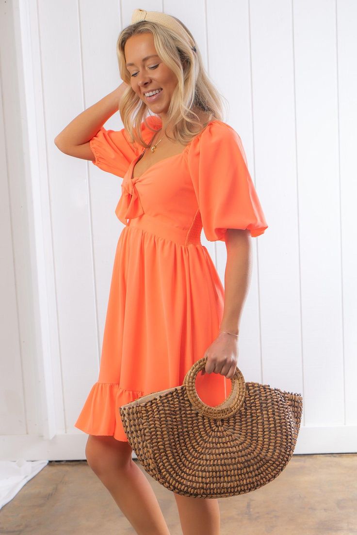 Get ready to make a lasting impression with the Nour Orange Creamsicle Mini Dress. This dress is all about fun and flirty vibes with its vibrant creamsicle hue and irresistible sweetheart neckline. The flowy and free silhouette adds an alluring appeal, while the smocked back ensures a comfortable fit. With front bow detailing, this dress adds a charming touch to your ensemble. Style it with wedges and statement jewelry for a trendy and complete look that is perfect for any occasion. Whether it's Trendy Orange Beach Dress, Trendy Mini Dress With Sweetheart Neckline For Spring, Summer Dresses With Sweetheart Neckline, Flowy Summer Dress With Sweetheart Neckline, Flirty Midi Dress With Sweetheart Neckline For Brunch, Flirty Short Sleeve Midi Dress For Summer, Orange Mini Length Summer Dress, Summer Orange Mini Dress, Summer Mini Length Orange Dress