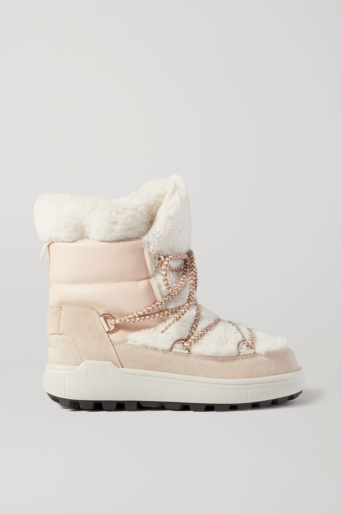 a pair of white and pink snow boots with chains on the bottom, side view