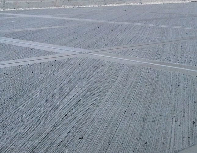 a person riding a skateboard on top of an empty parking lot in the snow