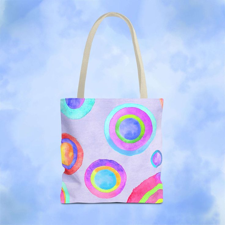 a colorful bag hanging in the air on a blue sky with white clouds behind it