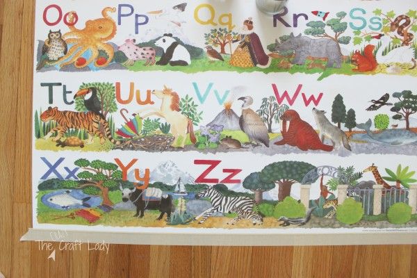 the children's alphabet wall hanging is decorated with animals and letters on white paper