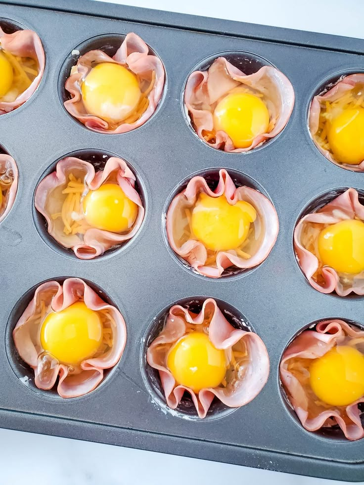 muffins with ham and an egg in a muffin tin