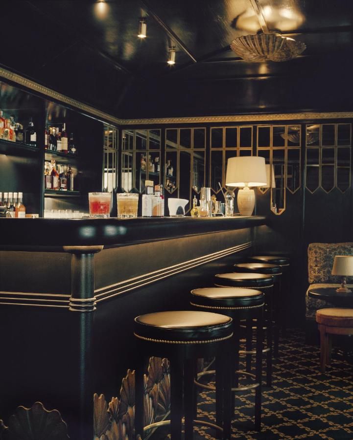 a dimly lit bar with stools in front of it