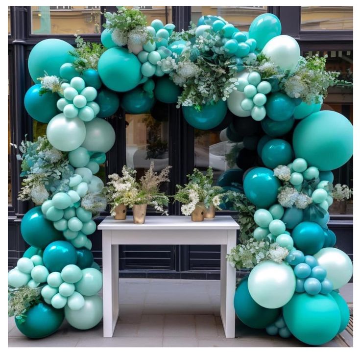 an arch made out of balloons and greenery