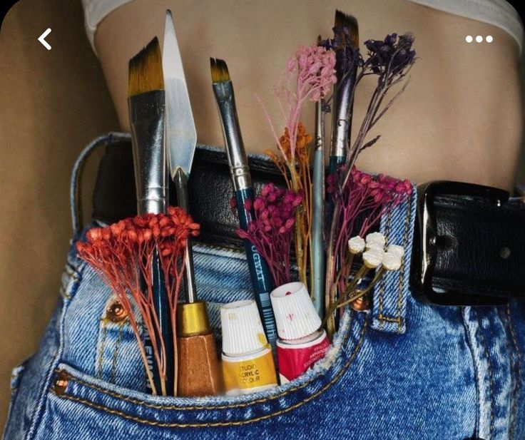 a woman's waist with various makeup and beauty products in her pocket, including brushes