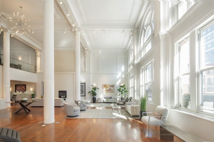 a large living room with high ceilings and wooden floors