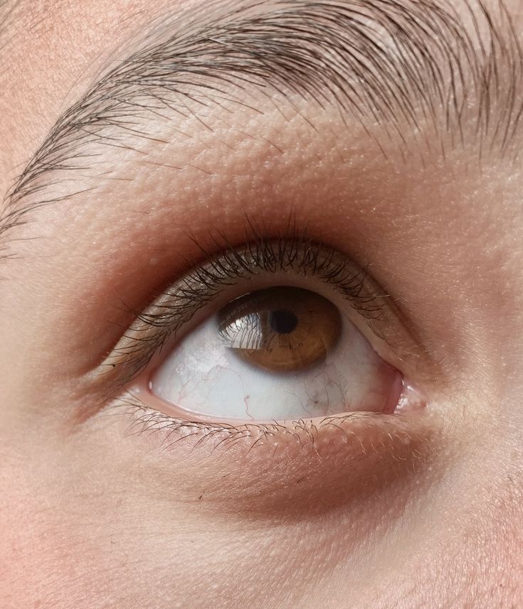 an eye looking down at the camera with brown and white eyeshade on it