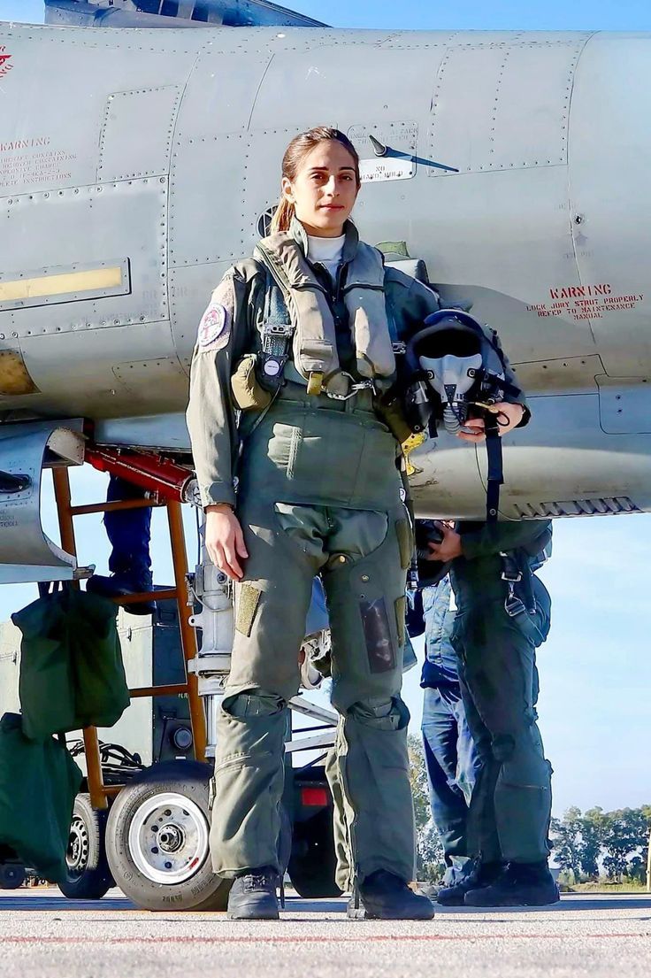 a woman standing in front of an airplane with another person next to her looking at the camera