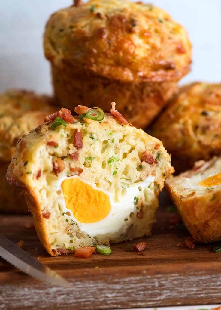 some muffins with an egg inside on a cutting board