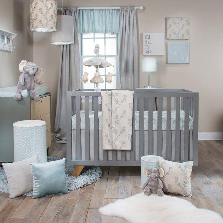 a baby's room with a crib, teddy bear and pillows