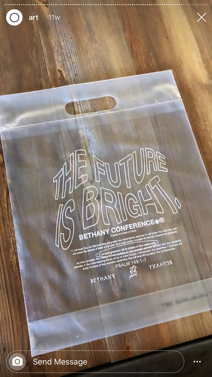 a plastic bag with the words, the future is bright behind it on a wooden table