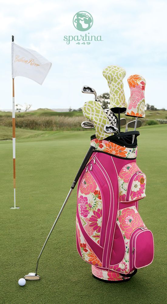 a pink golf bag sitting on top of a green field next to a white flag