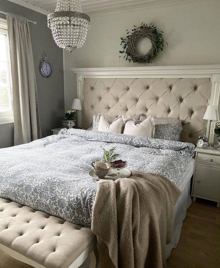 a bedroom with a large bed and chandelier