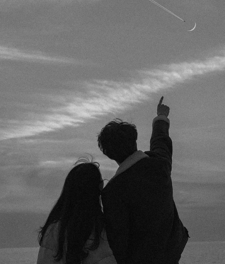 a man and woman flying a kite on the beach