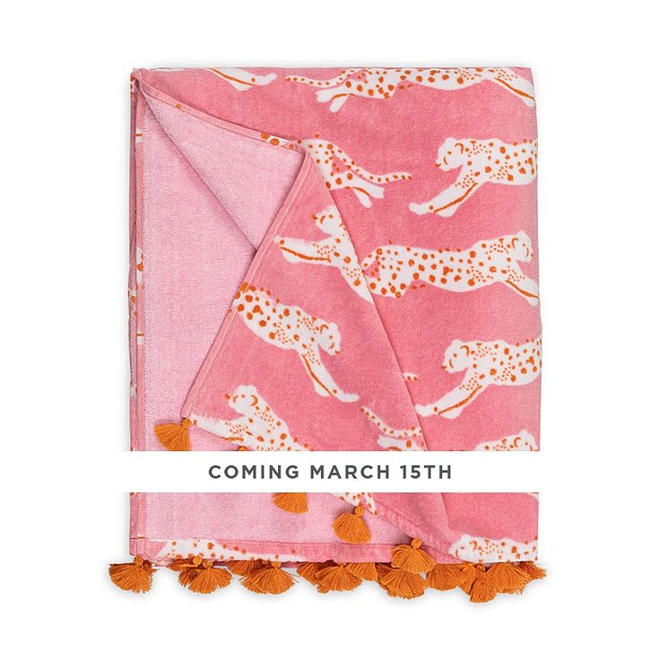 a pink blanket with orange pom poms on it