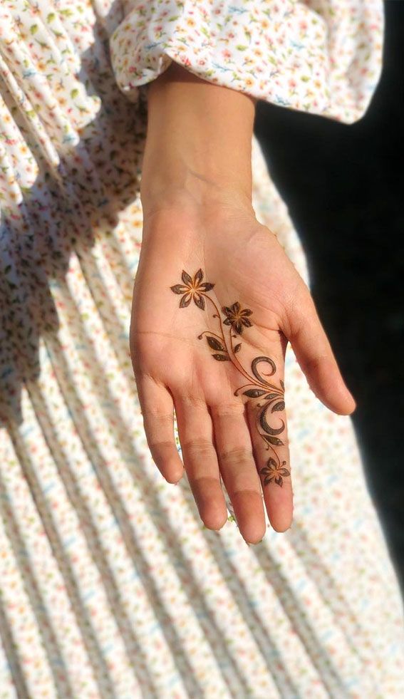 a woman's hand with a flower tattoo on it